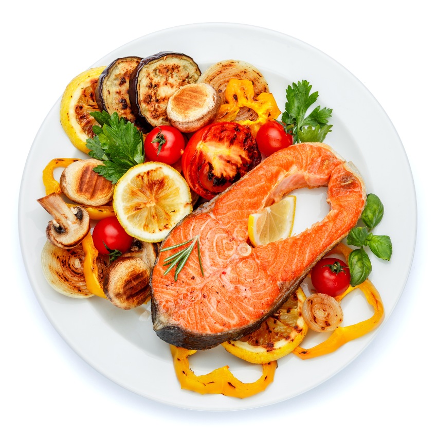 Studioaufnahme von knusprig gebratenem Lachssteak - Fisch mit mediterranem Gemüse
