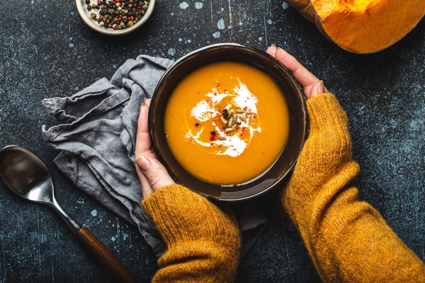 Hände an einer kleinen Schüssel Kürbissuppe - Kürbissuppen-Rezepte