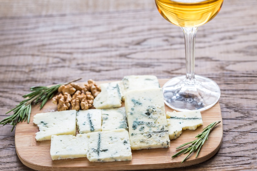 Weißwein und Käse auf einem Holztablett