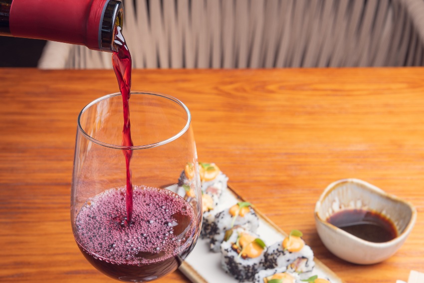 Junges Paar isst Sushi und trinkt Rotwein - Welcher Wein zu Sushi?