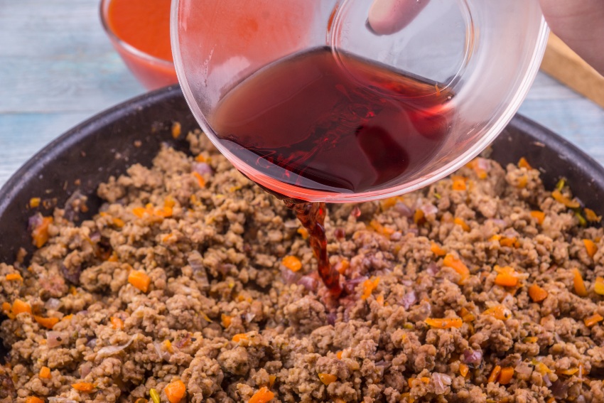 Hackfleisch wird mit Rotwein abgeloescht